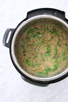 a pot filled with food sitting on top of a counter next to a white table