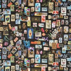 a wall covered in lots of different types of cards and magnets on black background