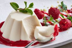 a dessert with raspberries and cream on a white plate