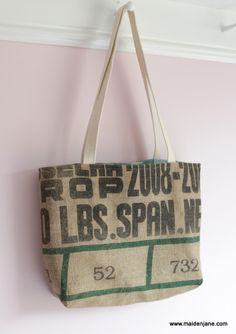 a bag hanging up on a wall with the name and number printed on it,