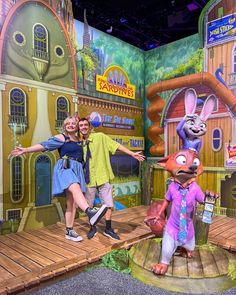 two people posing for a photo in front of an animated set