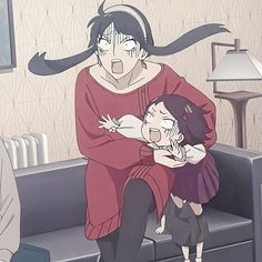 two people sitting on a couch with their arms around each other and one person holding the child