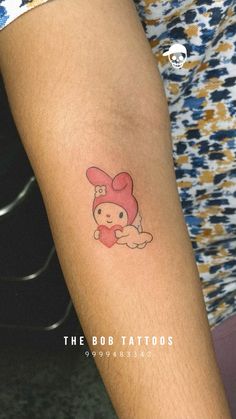 a small tattoo on the arm of a person with a pink hat and teddy bear