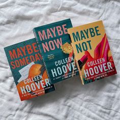 three books laying on top of a bed next to each other in front of a white sheet