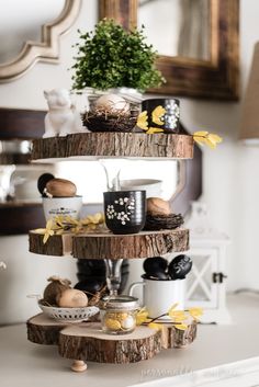 a three tiered wooden shelf with coffee cups and other items on top of it