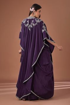 Purple attached cancan draped lehenga. Paired with zari and mirror work padded blouse, matching embroidered cape, detachable draped sash and scallop embroidered belt. - Aza Fashions Wedding Kaftan With Zari Work And Cape Sleeves, Festive Purple Kaftan For Wedding, Festive Purple Wedding Kaftan, Draped Kaftan For Wedding, Traditional Drape Kaftan For Wedding And Diwali, Wedding Kaftan With Pallu For Navratri, Festive Evening Gown With Dabka Detailing, Wedding Kaftan With Pallu In Traditional Drape, Wedding Kaftan With Pallu And Traditional Drape