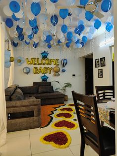 a living room filled with furniture and lots of balloons hanging from the ceiling above it