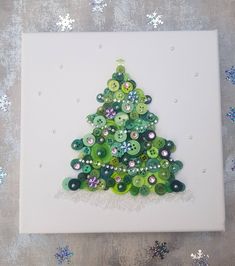 a christmas tree made out of buttons on a canvas