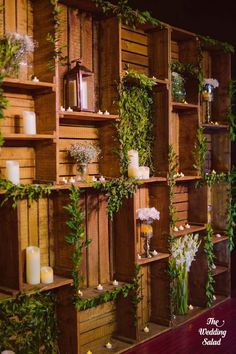 wooden shelves with candles, flowers and greenery on them are arranged in order to display the wedding bouquets