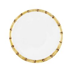 a white and gold plate with bamboo decoration on the rim, against a white background