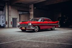 an old red car parked in a garage