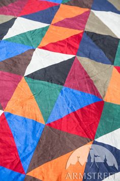 a multicolored quilt is laying on the floor