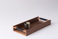 a wooden tray with a cup and knife on it