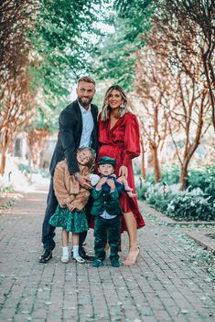 a family posing for a photo in front of some trees