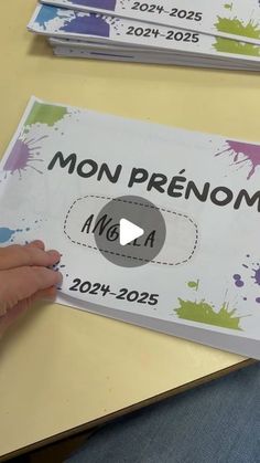 a person holding up a sign with the words mon prenom on it in front of them