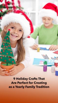 two children in santa hats sitting at a table with christmas decorations and crafts on it