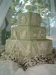 a green wedding cake sitting on top of a table