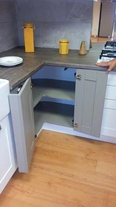 a small kitchen with white appliances and wood flooring on the counter top, is shown