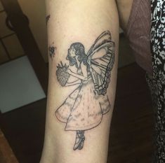 a woman's arm with a tattoo on it that has a fairy holding a flower