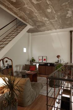 a living room filled with furniture and a stair case