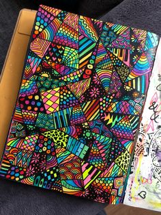 an open notebook with colorful designs on it