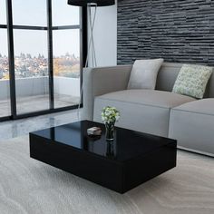 a living room with a couch, coffee table and large windows