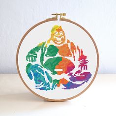 a cross stitch pattern with a person sitting in the center