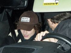 a man and woman sitting in the drivers seat of a car