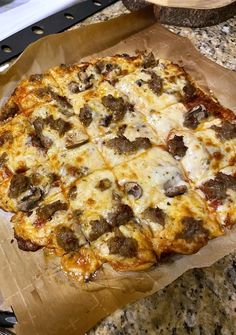 a pizza sitting on top of a table covered in cheese and toppings with meatballs