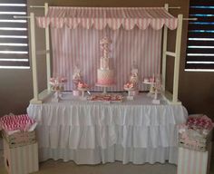 a pink and white dessert table set up for a baby shower