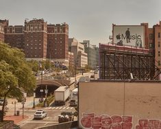 an old building with graffiti on it in the middle of a large city, next to some tall buildings