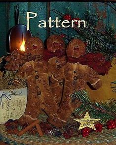 a group of gingerbread men standing on top of a table next to a lit candle