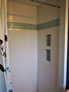 a bathroom with a shower, toilet and shelf on the wall next to the bathtub