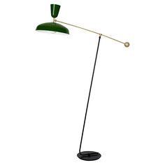 a green floor lamp with a black base and a white light on the top of it