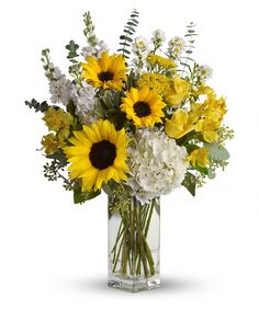 sunflowers and white carnations in a clear glass vase with greenery