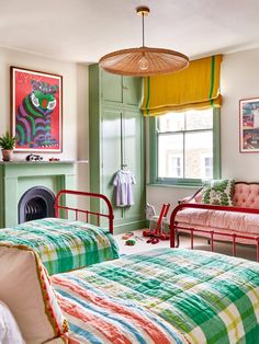 a bedroom with two beds, a couch and a fire place in the corner on the wall