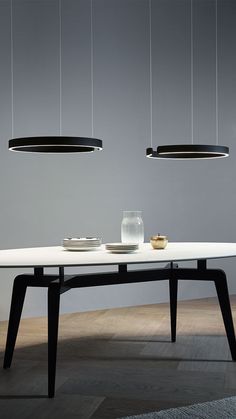 a white table with three lights hanging from it's sides and plates on the table