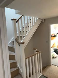 an open door leading to a living room with stairs and carpet on the floor in front of it