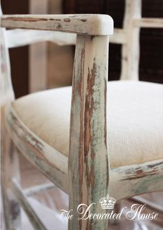 an old wooden chair with a white cushion