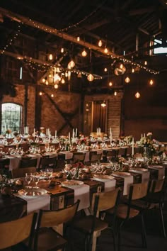 a long table is set up with place settings and candles for an elegant wedding reception