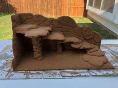 a clay sculpture of a bench and table in the shape of a cave on a patio