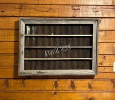 a rustic touch sign on the side of a wooden wall in front of a window