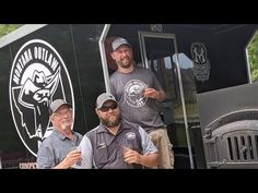 three men standing on the back of a truck with beer in their hands and smiling at the camera