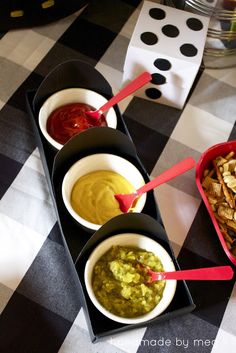 three bowls filled with guacamole, salsa and chips on a checkered tablecloth