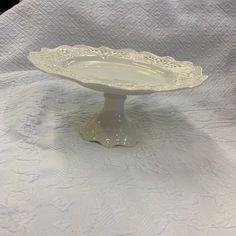 a white cake plate sitting on top of a table