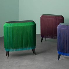 three different colored stools sitting next to each other