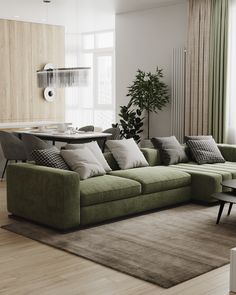 a living room filled with furniture and a large green couch next to a wooden table