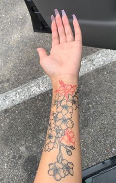 a woman's arm with flowers tattooed on it