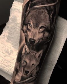 a man's arm with an image of two wolfs on it