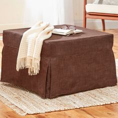 a brown ottoman sitting on top of a wooden floor